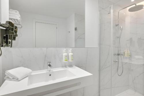 a white bathroom with a sink and a shower at B&B HOTEL Madrid San Fermin in Madrid