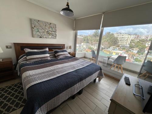 a bedroom with a large bed and a large window at La mejor terraza en el centro de Viña del Mar, cerca de todo in Viña del Mar