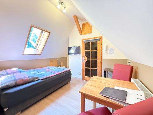 a bedroom with a bed and a wooden table at Schwarzwaldhaus Zwink Ferienhaus in Enzklösterle