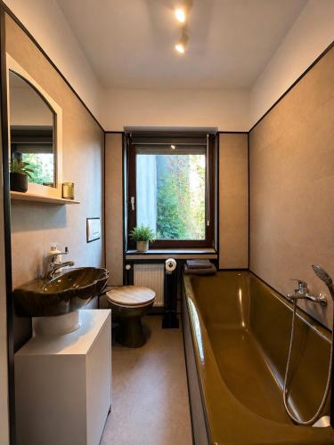 a bathroom with a tub and a sink and a toilet at Landblick Halver - Ferienwohnung mit Balkon in Halver