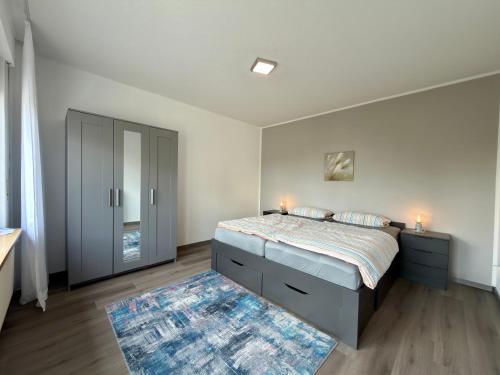 a bedroom with a bed and a blue rug at Landblick Halver - Ferienwohnung mit Balkon in Halver