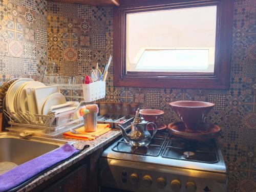 a kitchen with a stove and a sink and a window at Antic house in Agadir