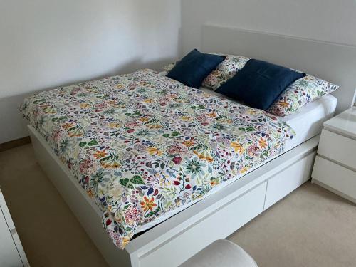 a white bed with a floral quilt on it at Apartment in Delitzsch