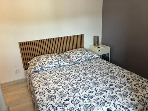 a bedroom with a bed with a blue and white comforter at Gîte de chenieux in Saint-Victor-sur-Loire