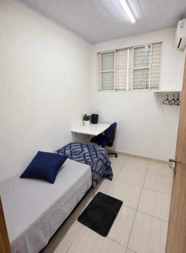 a bedroom with a bed and a desk in it at Pousada da Juh in Campo Grande