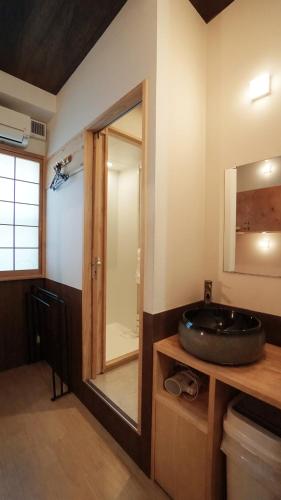 a bathroom with a sink and a mirror at Poly Hostel 2 Namba in Osaka