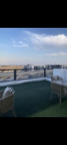 a balcony with two chairs and a view of the city at Tetou Hotel Cairo in Cairo