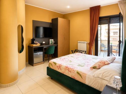 a bedroom with a bed and a desk and a television at Oasi Urbana in Casoria