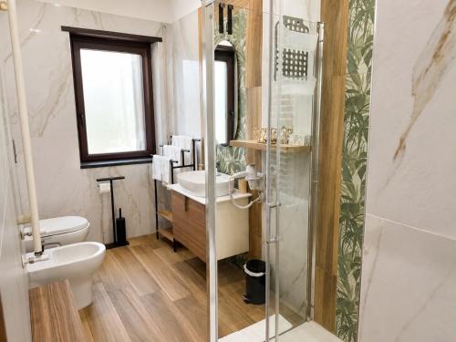 a bathroom with a toilet and a sink and a shower at Oasi Urbana in Casoria