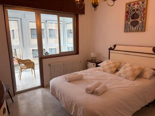 a bedroom with a bed with two towels on it at A Casa do Miradoiro in Puentedeume