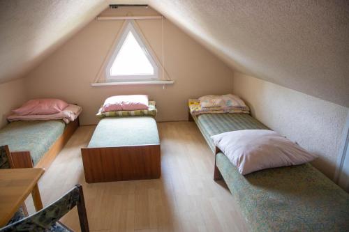 a attic room with two beds and a window at Willa Świerk in Susiec