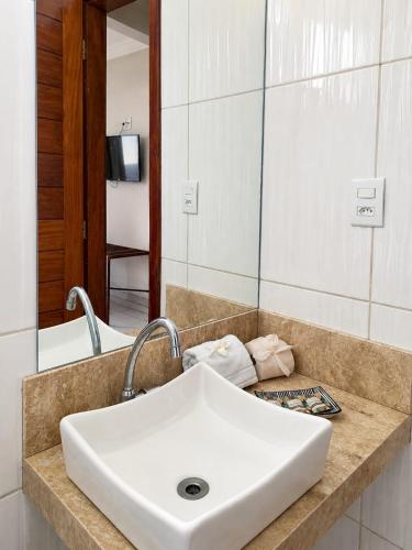 a bathroom with a white sink and a mirror at Pousada Caliandra Pipa in Pipa