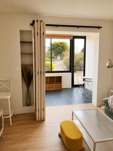 a living room with a table and a window at Le Spot - Capbreton - Au calme et à deux pas de la mer in Capbreton