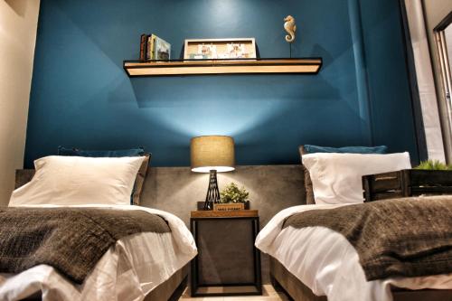 - une chambre avec 2 lits et un mur bleu dans l'établissement Ku at sea, à Ko Samet