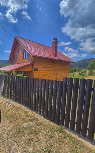 a wooden fence in front of a house at Apuseni Wood House in Mătişeşti