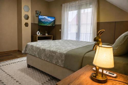 a bedroom with a bed and a table with a lamp at North Forest in Žabljak