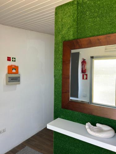 a mirror in a room with a green wall at Sky carvoeiro in Mação