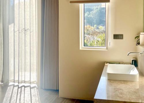 a bathroom with a sink and a window at Book NOW & Chat, Wake in Mountain,Free Shuttle,Aside National Park, Combo Stay in Tianmen city center, English Speaking Assistant in Jiawan