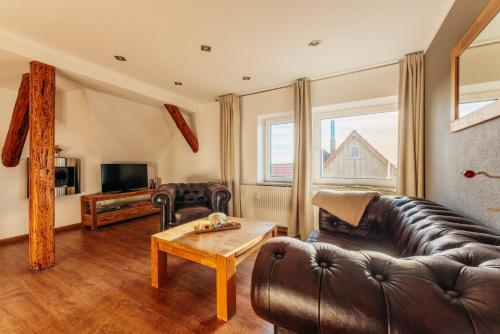 a living room with a leather couch and a table at Bergpanorama in Sankt Andreasberg