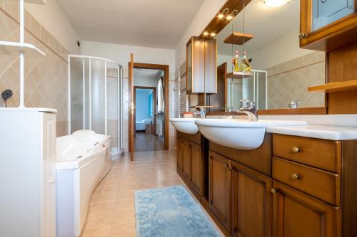a bathroom with two sinks and a tub and a toilet at ROSSO DI SERA Bed & Breakfast in Tarcento