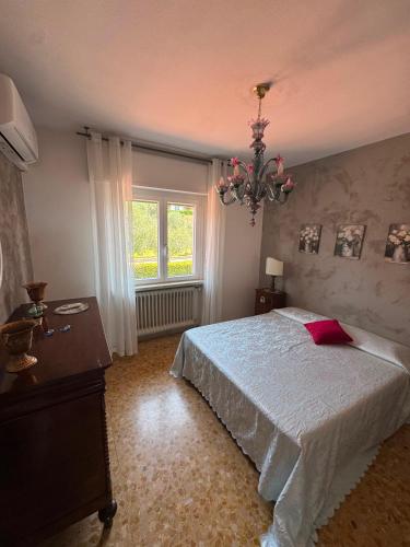 a bedroom with a large bed and a chandelier at Viola Apartment Monte Felice in Bardolino