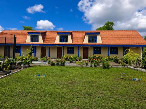 a house with an orange roof and a yard at Casa KariAna in Murighiol