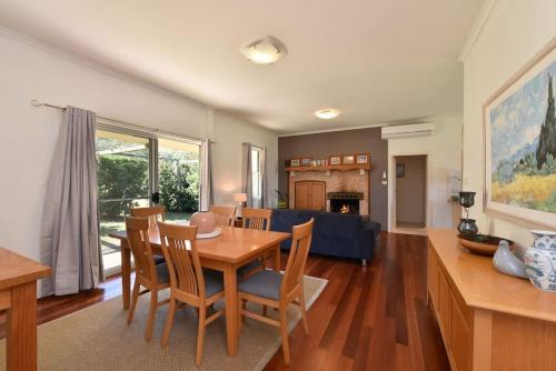 a dining room and living room with a table and chairs at Somerville Wine Cottage Hideaway 3-Bedroom Cottage Near Broke Wineries in Broke