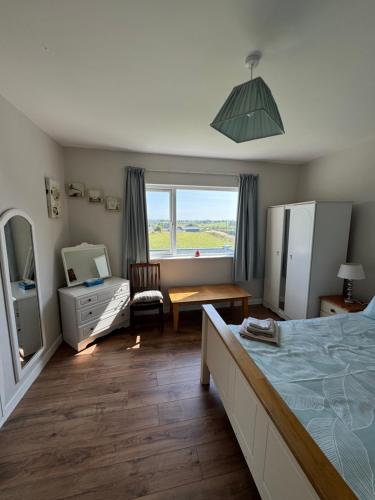 a bedroom with a bed and a desk and a window at Meadow View Cottage in Clooncullin Bridge