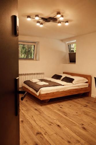 a bedroom with a large bed and a ceiling at Apartament w Parku 2 in Żywiec
