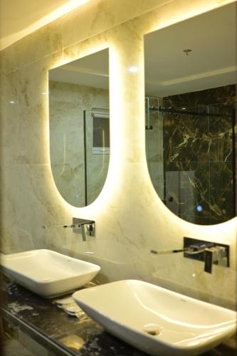 a bathroom with a sink and a mirror at Dubai Palace Hotel in Sambriāl