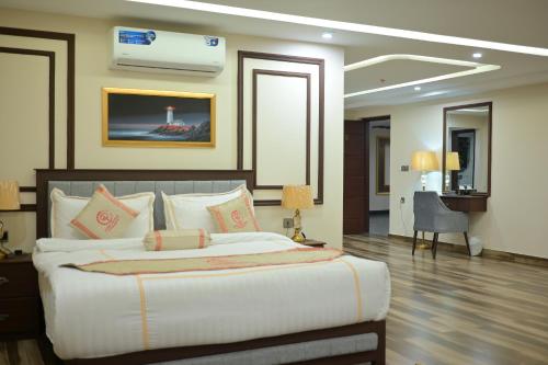a bedroom with a large bed and a desk in it at Dubai Palace Hotel in Sambriāl