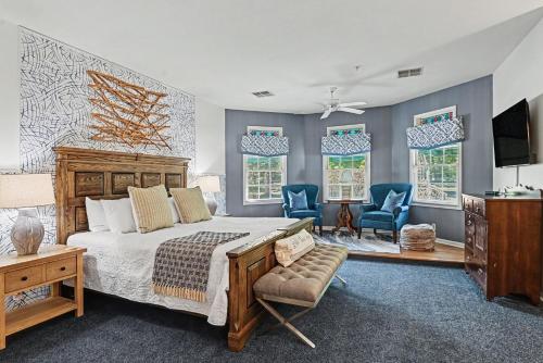 a bedroom with a large bed and two blue chairs at Inn at the Park Bed and Breakfast in South Haven