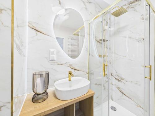 a bathroom with a sink and a shower at Apartament HUZAR 2 in Białystok