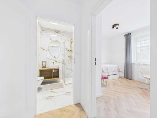 a white bathroom with a sink and a mirror at Apartament HUZAR 2 in Białystok