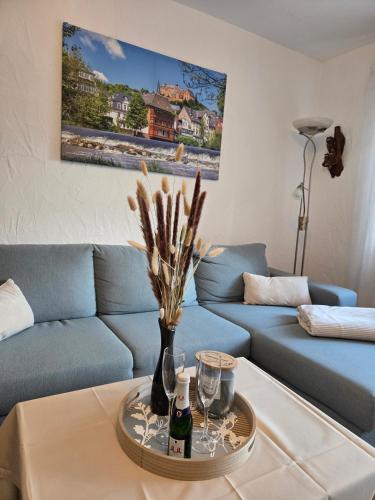 a living room with a blue couch and a table at Buchenau an der Lahn 