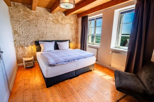 a bedroom with a bed and two windows at Erasmus WaldBlick Ferienhaus mit Ausblick in Saarburg