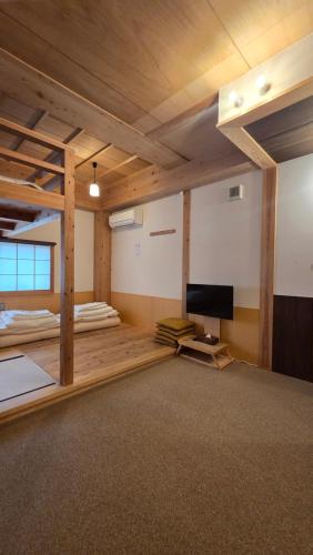 a room with two bunk beds and a flat screen tv at Poly Hostel 2 Namba in Osaka