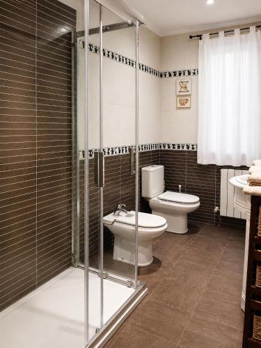 a bathroom with a toilet and a glass shower at El Rincón de Luarca in Luarca