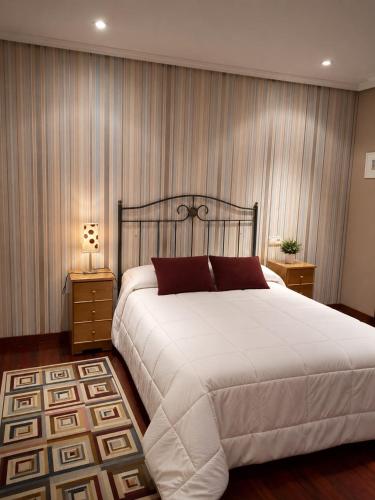 a bedroom with a large white bed and curtains at El Rincón de Luarca in Luarca