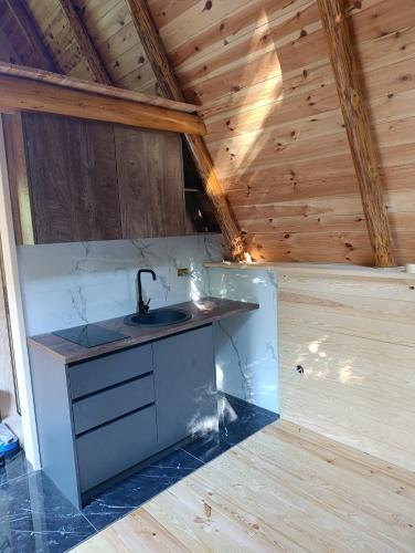 a kitchen with a sink and a wooden ceiling at Holiday bungalows Pajkovir in Kolašin