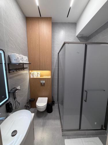 a bathroom with a shower and a toilet and a sink at Keruen in Almaty