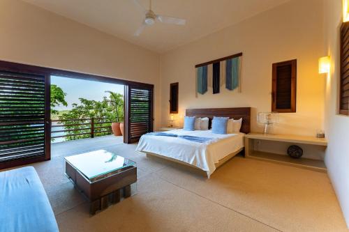 a large bedroom with a bed and a balcony at 2024 - Villa Serena in Santa Cruz Huatulco