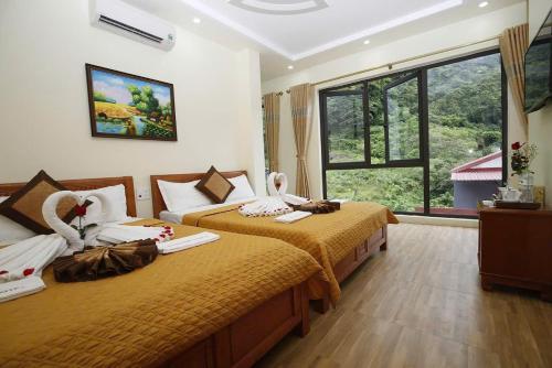 a hotel room with two beds and a window at Hoàng Phúc home - restaurant in Cat Ba
