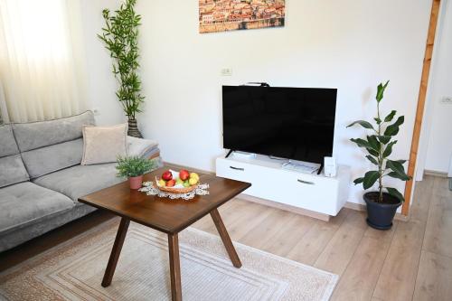 a living room with a coffee table and a television at The Parkside Villa Apartment II in Berat