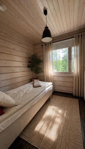 a bedroom with a large bed in a room with a window at Villa Narikko in Sysmä