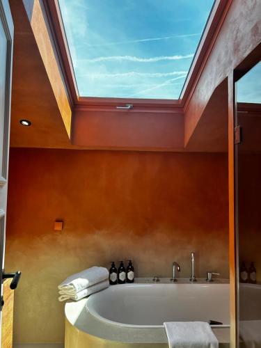 a bathroom with a bath tub with a skylight at Hotel Le Mathurin in Paris
