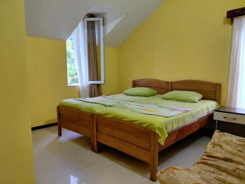 a bedroom with a bed with yellow walls and a window at Guest House Machaxela in Gonio
