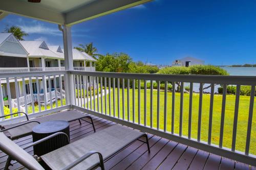 a porch with a bench and a view of the water at Blue House Getaway - 2BR 3BA Coastal Villa in Duck Key