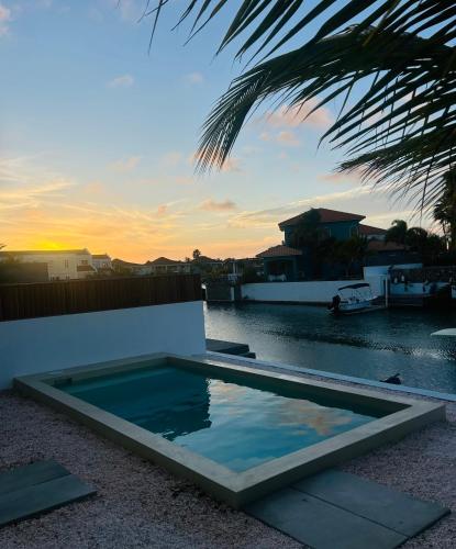 a swimming pool next to a body of water at Lagoon Lounge - Waterfront villa with private pool in Kralendijk