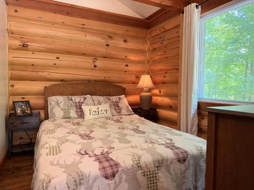 a bedroom with a bed in a room with wooden walls at Chalet Le Boisé SPA et Rivière in Brownsburg